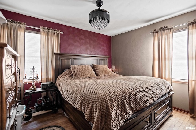 bedroom with an inviting chandelier and light hardwood / wood-style floors