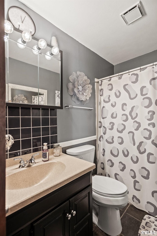 bathroom featuring vanity, tile patterned floors, and toilet