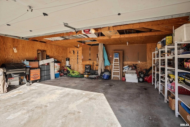 garage with a garage door opener and wood walls