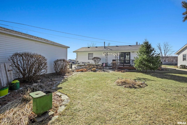 rear view of property featuring a lawn and a deck