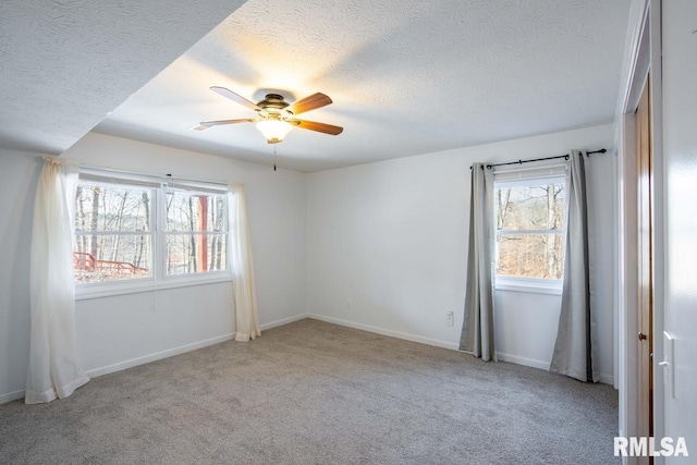 carpeted spare room with ceiling fan and a textured ceiling