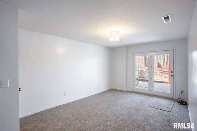 unfurnished room featuring carpet and a textured ceiling