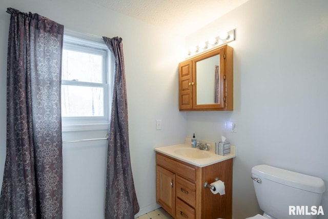 bathroom with vanity, a textured ceiling, and toilet