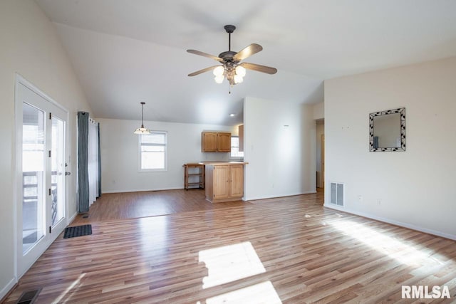 unfurnished living room with ceiling fan, light hardwood / wood-style floors, and vaulted ceiling