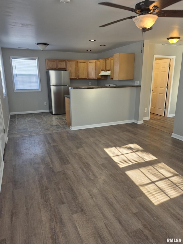 kitchen with dark wood-type flooring, stainless steel fridge, and ceiling fan