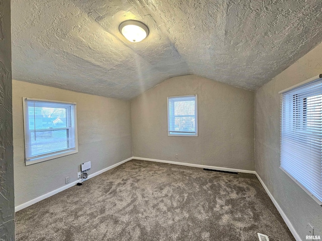 bonus room with vaulted ceiling, a textured ceiling, and carpet flooring