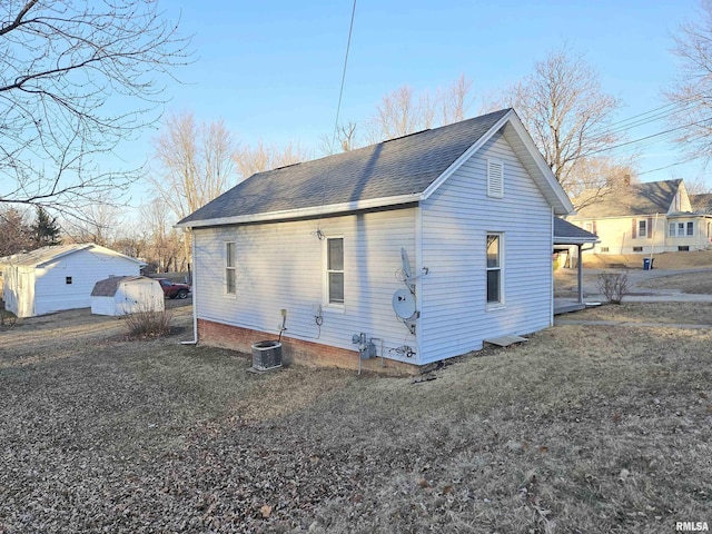 view of side of home with a yard and central air condition unit