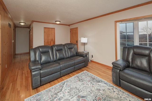 living room featuring ornamental molding, hardwood / wood-style floors, and a textured ceiling