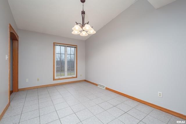 spare room with lofted ceiling and a chandelier