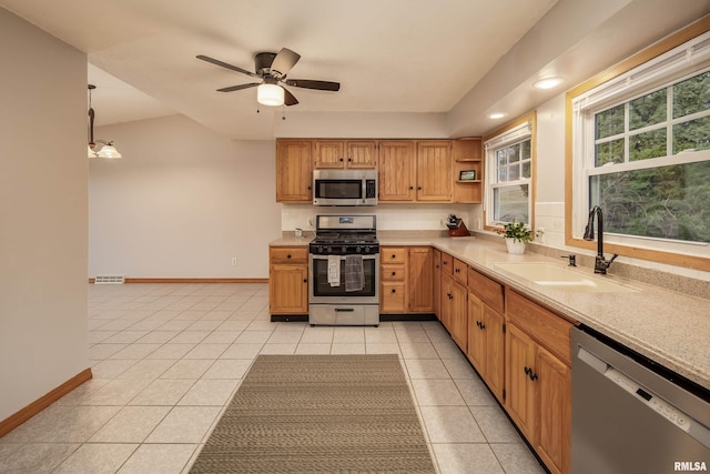 kitchen with sink, decorative light fixtures, stainless steel appliances, and light tile patterned flooring