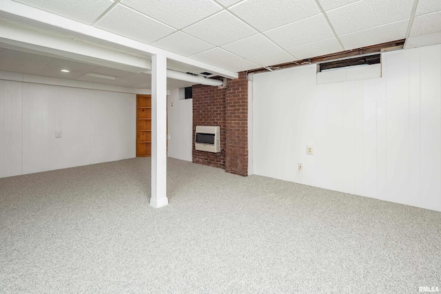 basement with heating unit, a fireplace, a paneled ceiling, and carpet