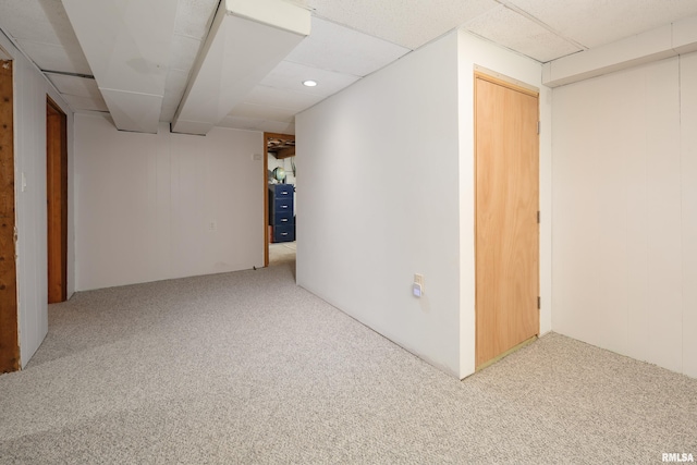 basement featuring carpet flooring and a drop ceiling