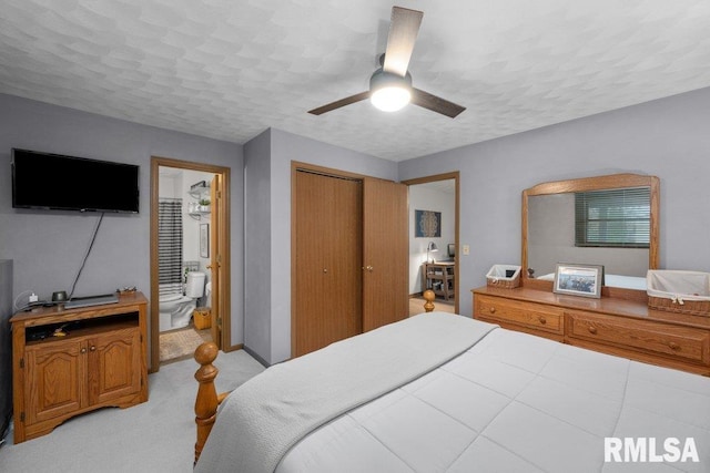 bedroom with ceiling fan, connected bathroom, a textured ceiling, light colored carpet, and a closet