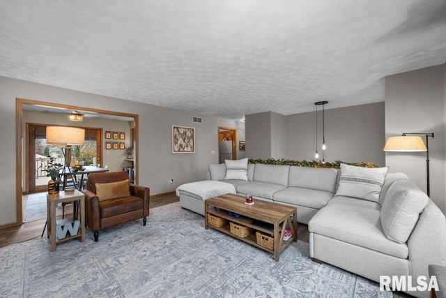 living room featuring a textured ceiling and light wood-type flooring