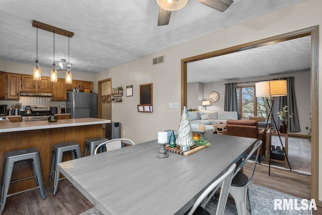 dining area with dark hardwood / wood-style floors, a textured ceiling, and ceiling fan