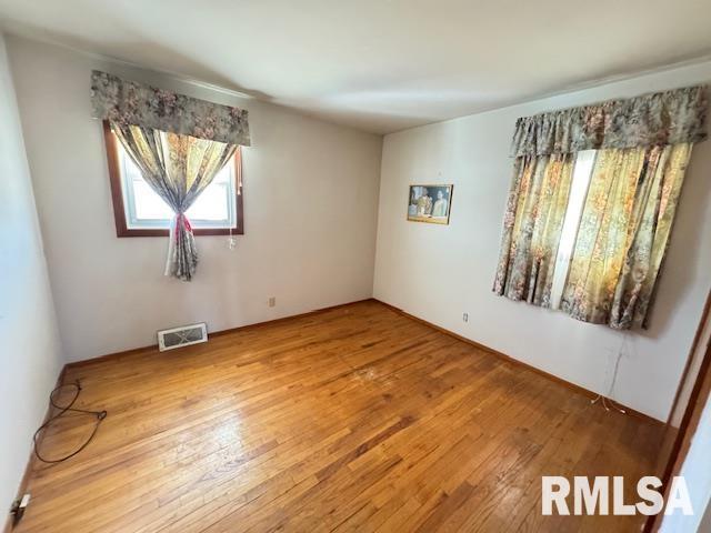 unfurnished room featuring hardwood / wood-style flooring