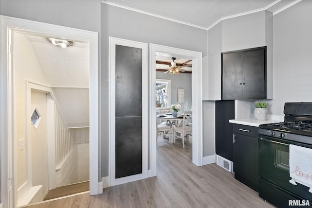 kitchen featuring black gas range, light hardwood / wood-style flooring, ornamental molding, and ceiling fan