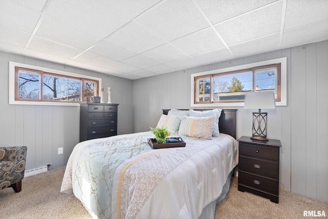 bedroom featuring light colored carpet, a drop ceiling, and a baseboard heating unit