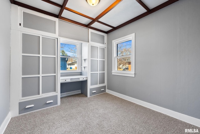 interior space with a baseboard radiator, carpet, coffered ceiling, and built in desk