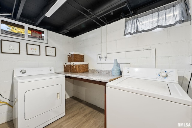 clothes washing area featuring washing machine and clothes dryer and light hardwood / wood-style flooring