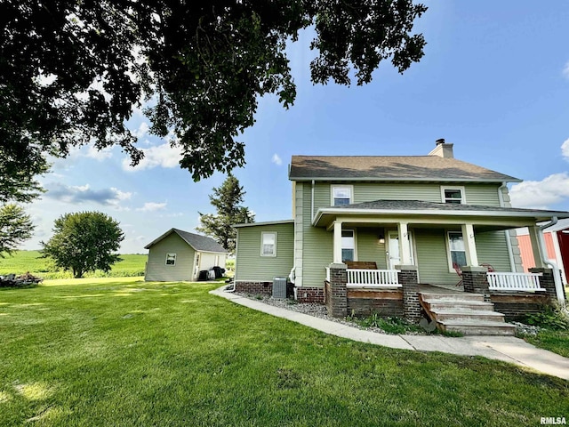 view of front of house with central AC unit, a front yard, and covered porch