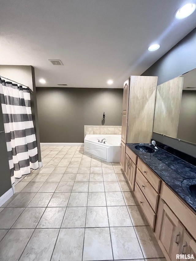 bathroom featuring tile patterned flooring, vanity, and a bath