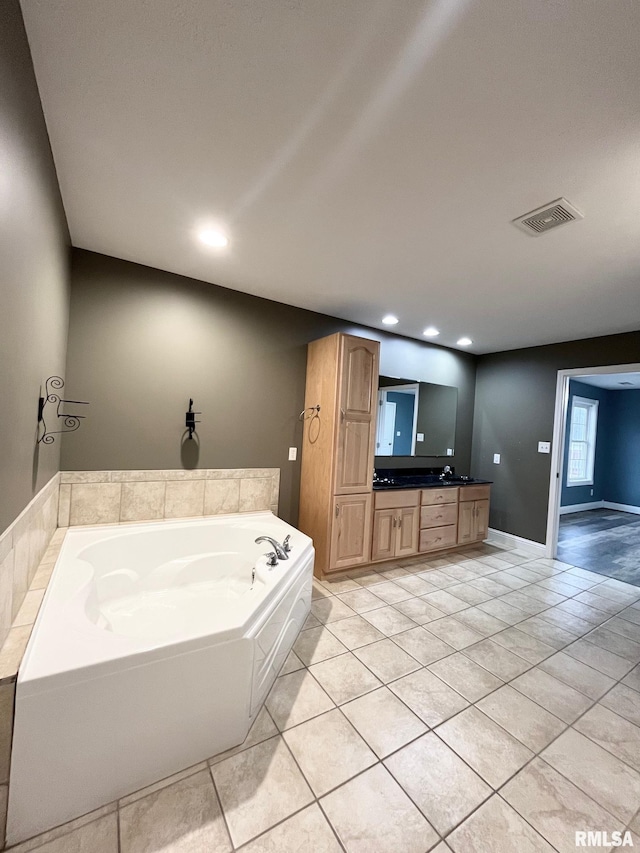 bathroom featuring vanity, a tub to relax in, and tile patterned floors