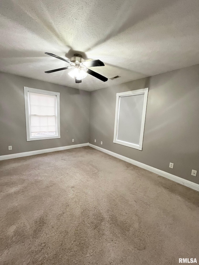 unfurnished room featuring ceiling fan, carpet floors, and a textured ceiling