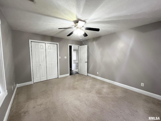 unfurnished bedroom with ceiling fan, a closet, a textured ceiling, and carpet