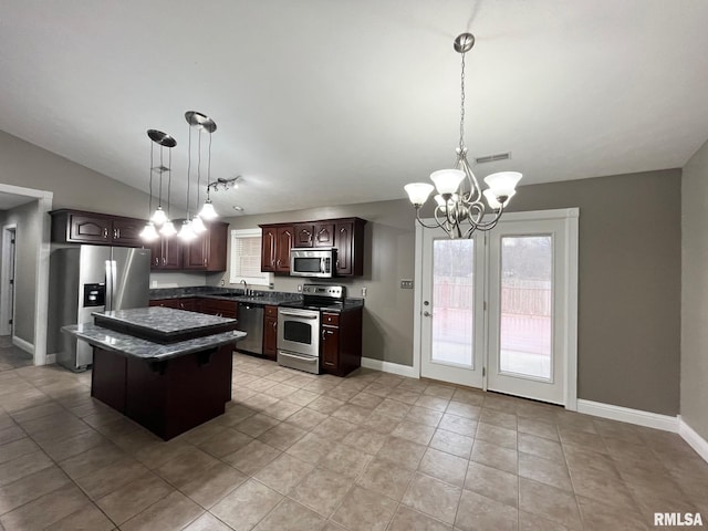 kitchen with pendant lighting, sink, appliances with stainless steel finishes, a center island, and dark brown cabinetry