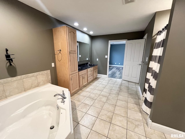 bathroom with tile patterned flooring, vanity, and a bathing tub