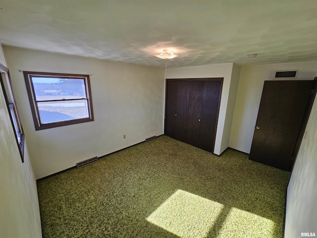 unfurnished bedroom with light colored carpet and a closet