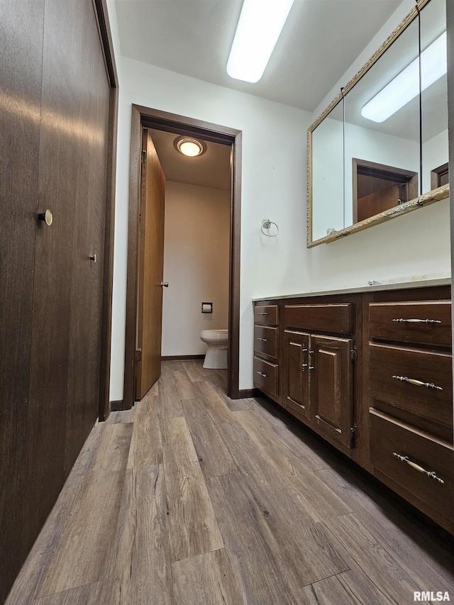 bathroom with vanity, toilet, and hardwood / wood-style floors