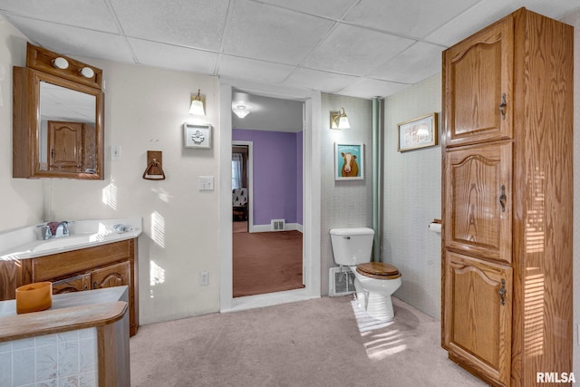 bathroom featuring vanity, a paneled ceiling, and toilet