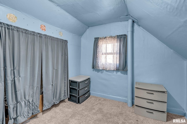 bonus room with vaulted ceiling and light carpet