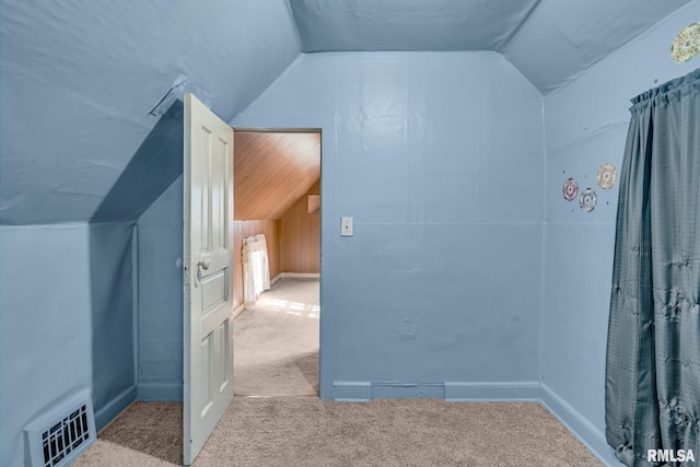 additional living space with light colored carpet and vaulted ceiling