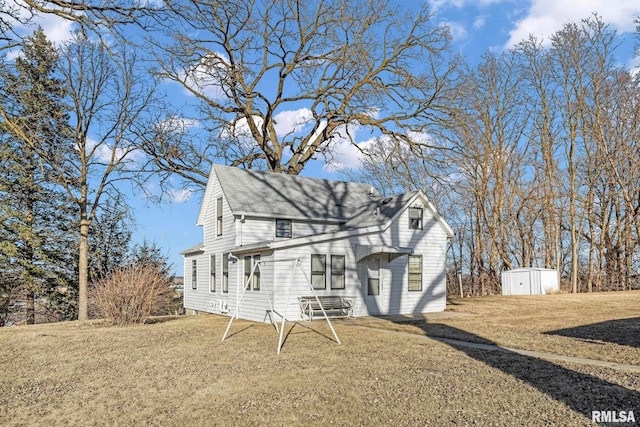 view of front facade featuring a front yard and a storage shed