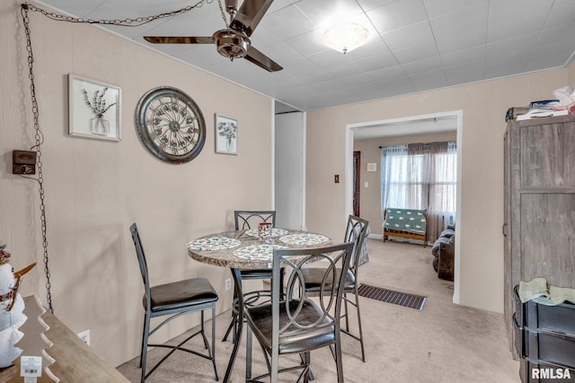 carpeted dining area featuring ceiling fan