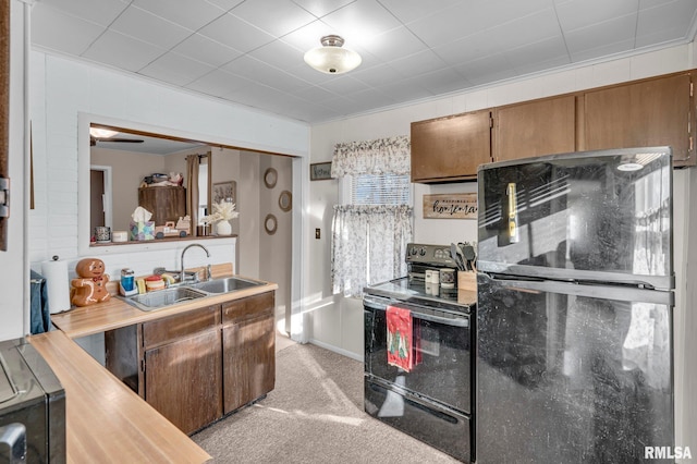 kitchen featuring light carpet, sink, ornamental molding, and black appliances