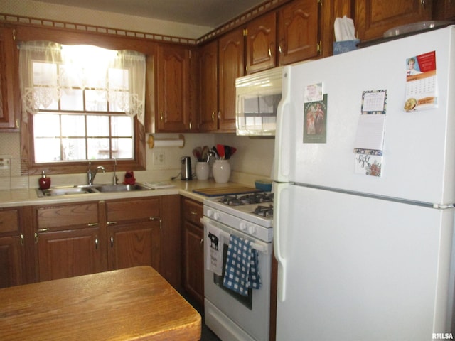 kitchen featuring tasteful backsplash, sink, and white appliances