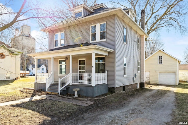 view of front of property featuring a garage, an outdoor structure, and covered porch