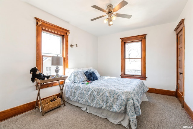 carpeted bedroom with multiple windows and ceiling fan