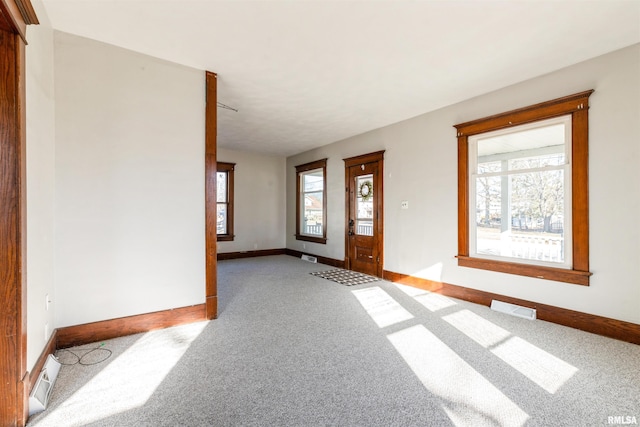 entrance foyer with a wealth of natural light and light colored carpet