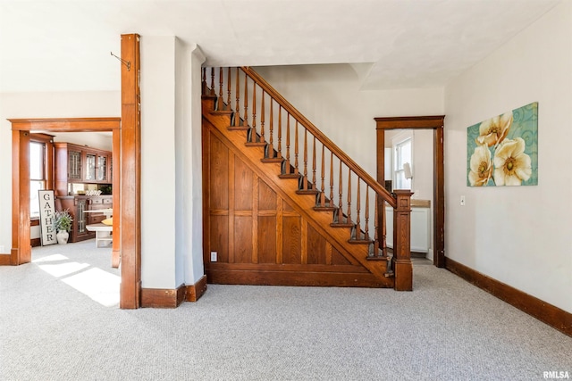 staircase with a healthy amount of sunlight and carpet flooring