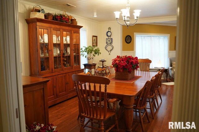 25065 Rock Springs Hollow Rd, Thebes, IL 62990 - dining space with crown molding, a decorative wall, a chandelier, and dark wood-type flooring