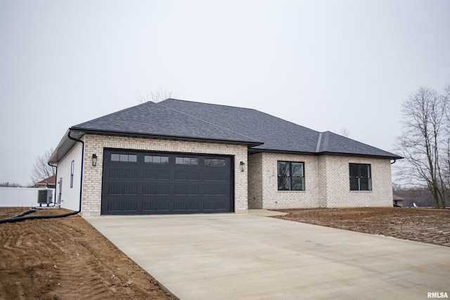 view of front of home with a garage and central AC