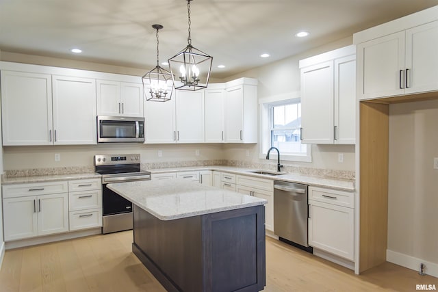 kitchen featuring sink, stainless steel appliances, white cabinets, and a kitchen island