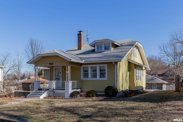 view of front of house featuring covered porch and a front yard