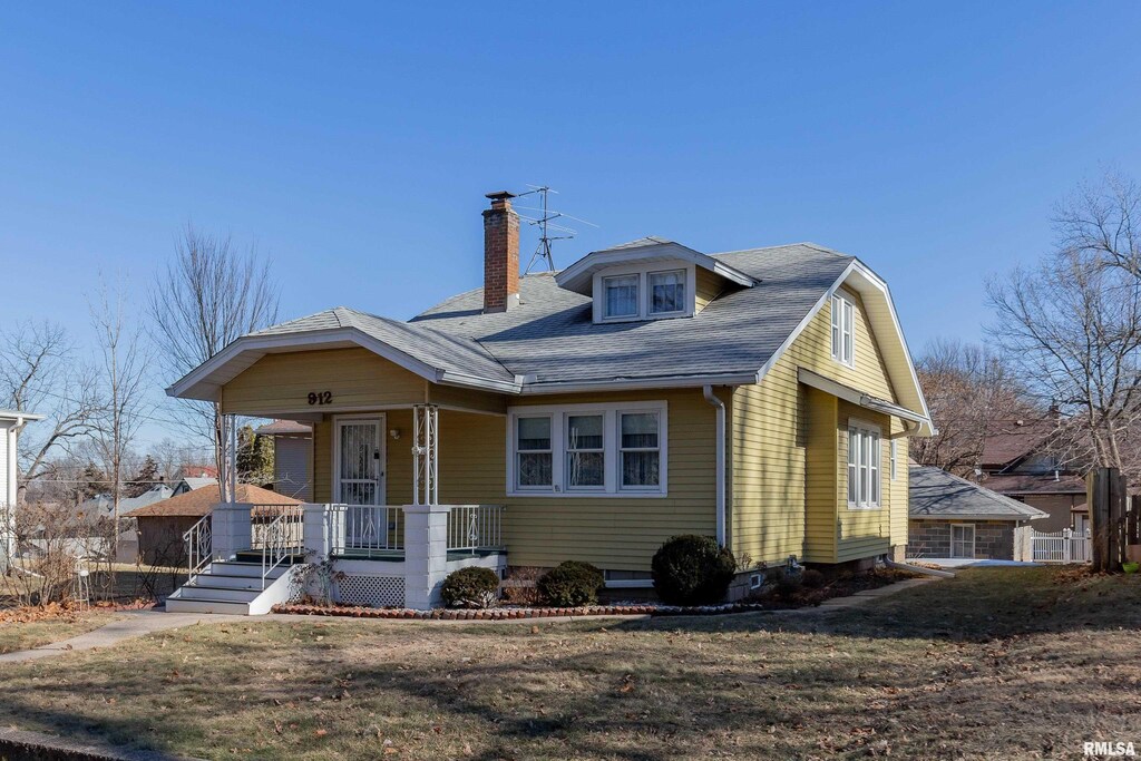 view of front of property featuring covered porch and a front lawn