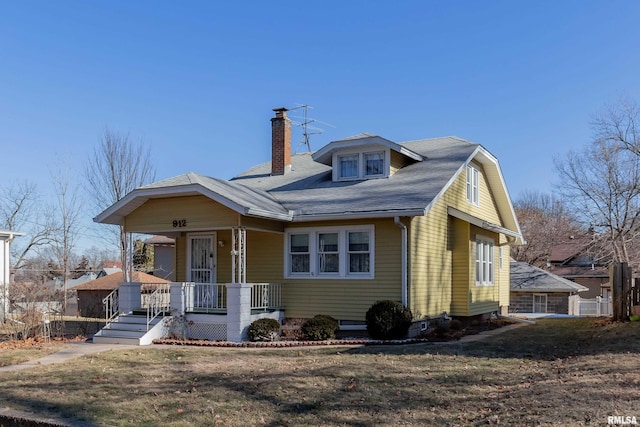 view of front of property featuring covered porch and a front lawn